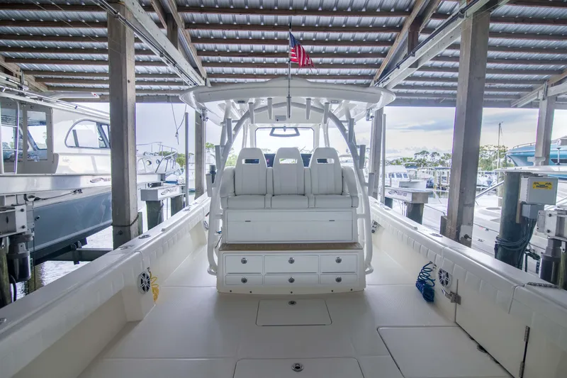 Slide: The Image of 2021 Regulator 41 boat interior with seating and storage, docked under a covered marina. - 12