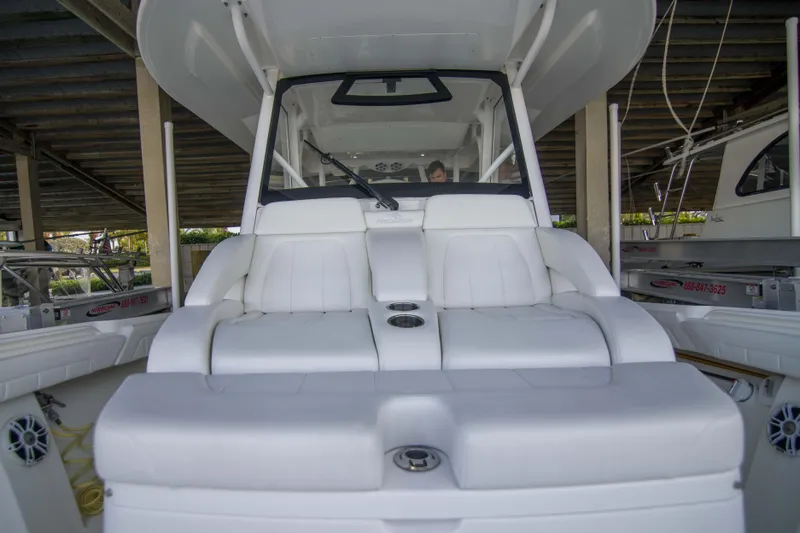 Slide: The Image of 2021 Regulator 41 boat interior with white seating under a covered dock. - 15