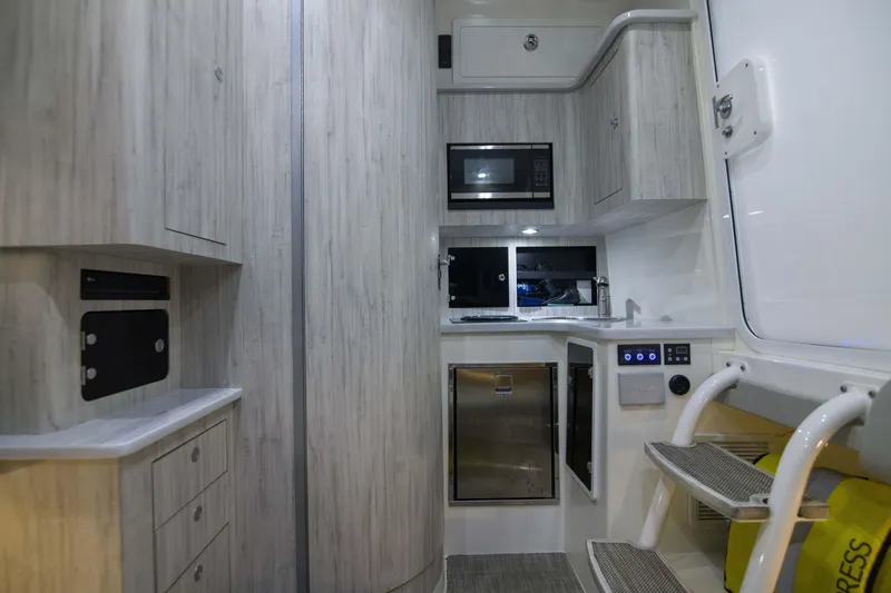 Slide: The Image of Interior of 2021 Regulator 41 boat featuring modern kitchen and storage cabinets. - 2