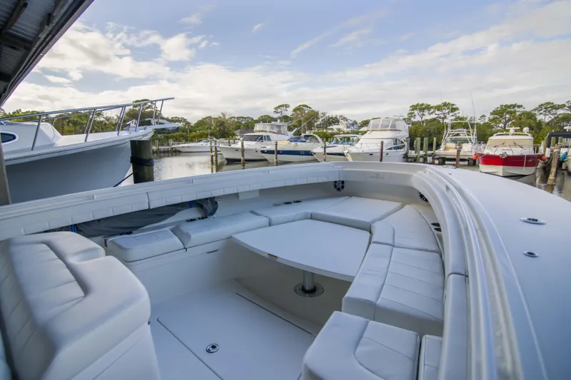 Slide: The Image of 2021 Regulator 41 boat with spacious seating at a marina, surrounded by other boats. - 23