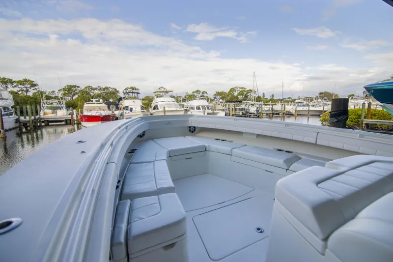 Slide: The Image of 2021 Regulator 41 boat with spacious seating, docked at a marina under a partly cloudy sky. - 25