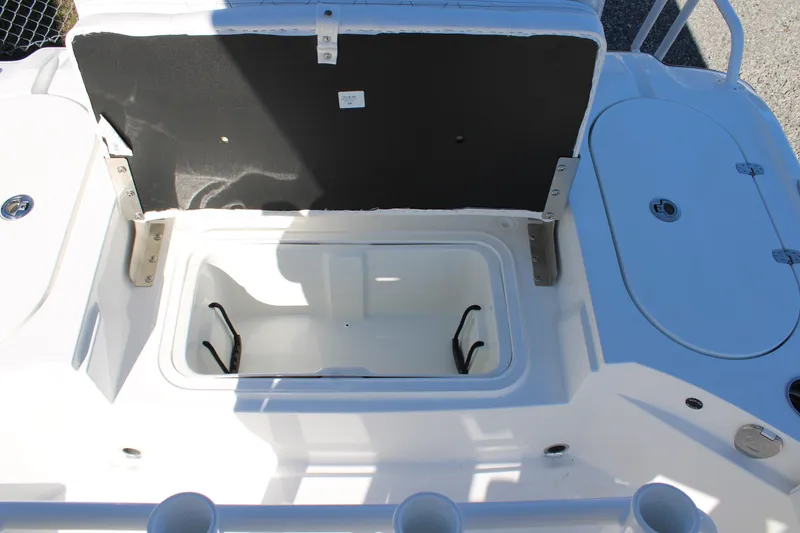 Slide: The Image of Open storage compartment on 2026 Blazer Bay 2440 boat, featuring cup holders and seating area. - 16