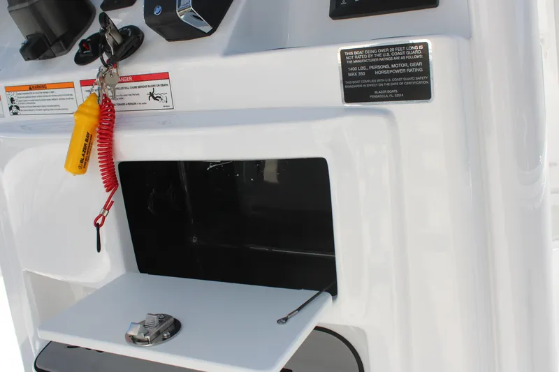 Slide: The Image of 2026 Blazer Bay 2440 boat dashboard with safety key and warning labels. - 32