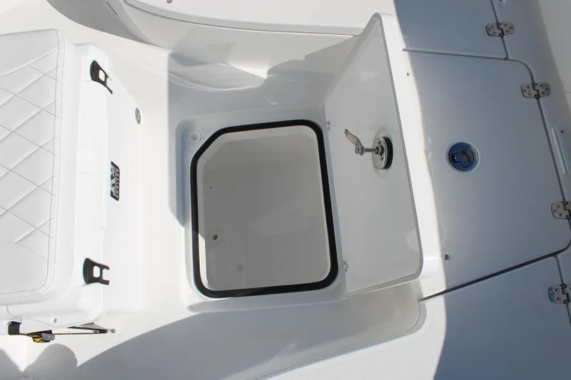 Slide: The Image of Open storage compartment on 2026 Blazer Bay 2440 boat, featuring white interior and secure latch. - 46