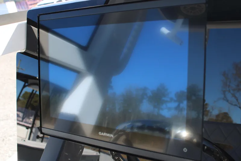 Slide: The Image of 2026 Blazer Bay 2440 boat with Garmin display screen, reflecting blue sky and trees. - 48