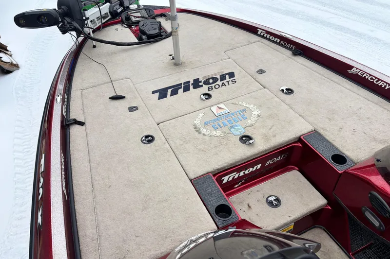 Slide: The Image of 2004 Triton Tr-20XDC boat deck with logos and fishing equipment. - 11