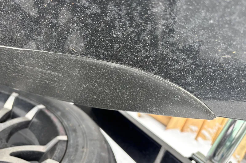 Slide: The Image of Close-up of a 2004 Triton Tr-20XDC boat detail with tire and textured surface. - 6