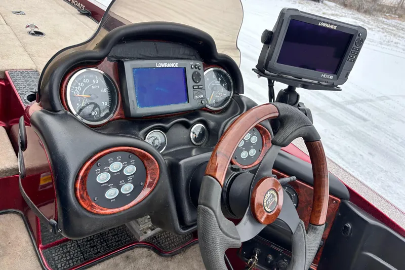 Slide: The Image of 2004 Triton Tr-20XDC boat dashboard with Lowrance electronics and wood-accented steering wheel. - 8