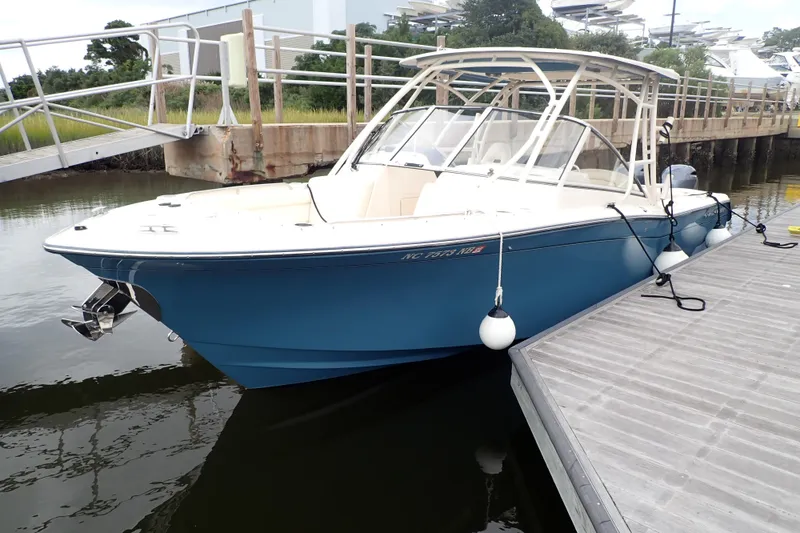 The Image of 2021 Grady-White Freedom 275 boat docked at marina, blue hull, white interior. - 0
