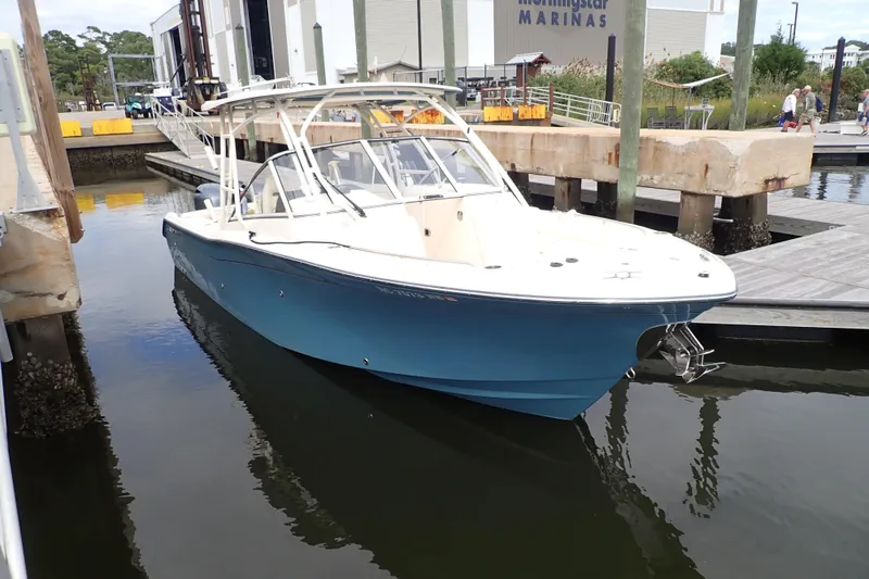 Slide: The Image of 2021 Grady-White Freedom 275 boat docked at marina, showcasing sleek design. - 1