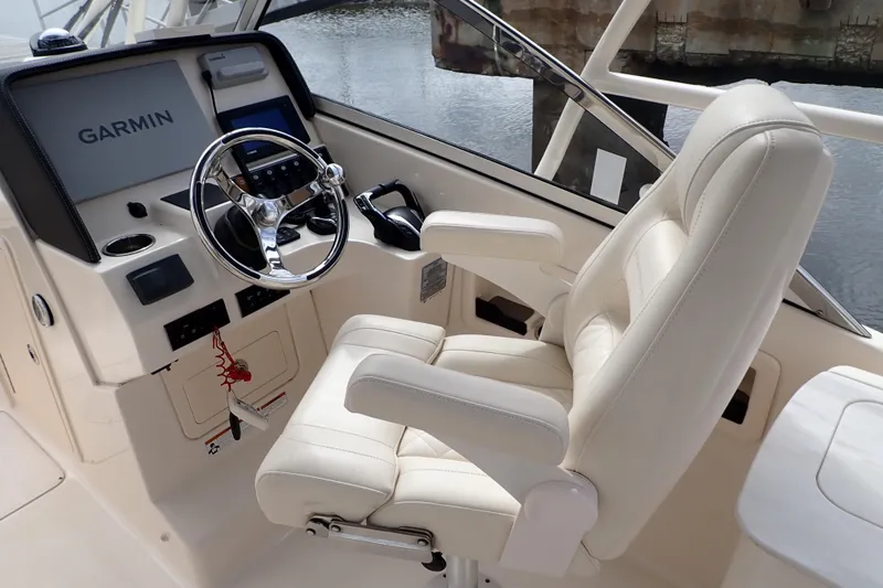 Slide: The Image of Captain's seat and helm of 2021 Grady-White Freedom 275 boat with Garmin navigation. - 15