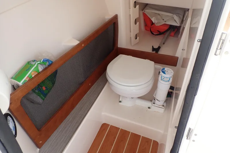 Slide: The Image of 2021 Grady-White Freedom 275 boat interior with compact marine toilet and storage. - 38