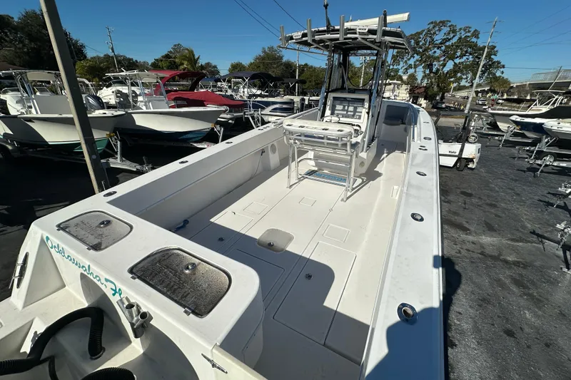 Slide: The Image of 2005 Contender 36 Cuddy boat with spacious deck and seating, displayed in a marina. - 13