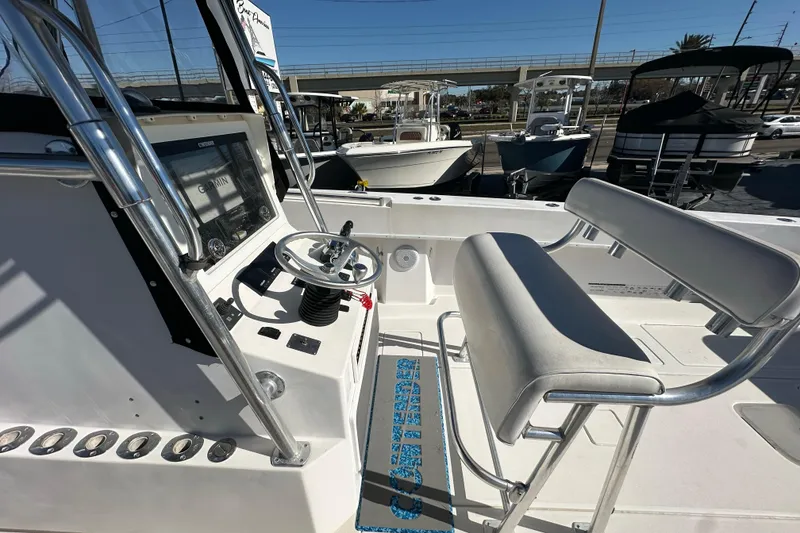 Slide: The Image of 2005 Contender 36 Cuddy boat cockpit with steering wheel and seating, docked outdoors. - 18