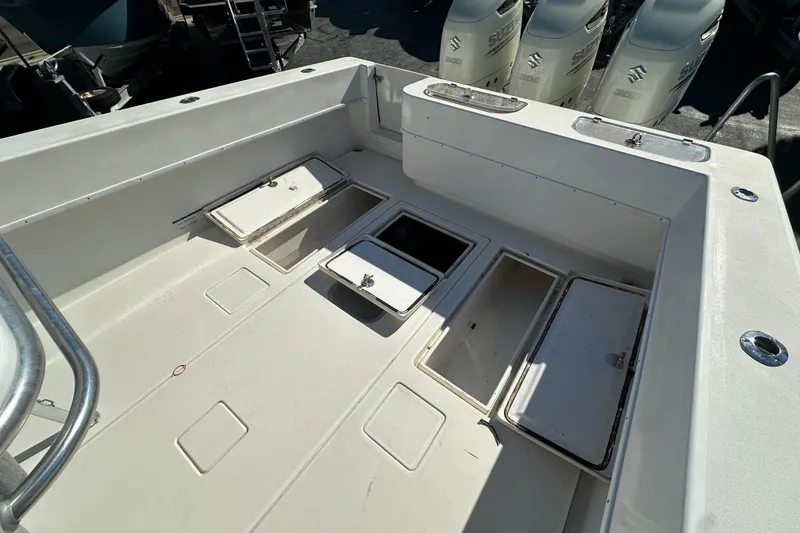 Slide: The Image of 2005 Contender 36 Cuddy boat deck with open storage compartments and Suzuki engines. - 21