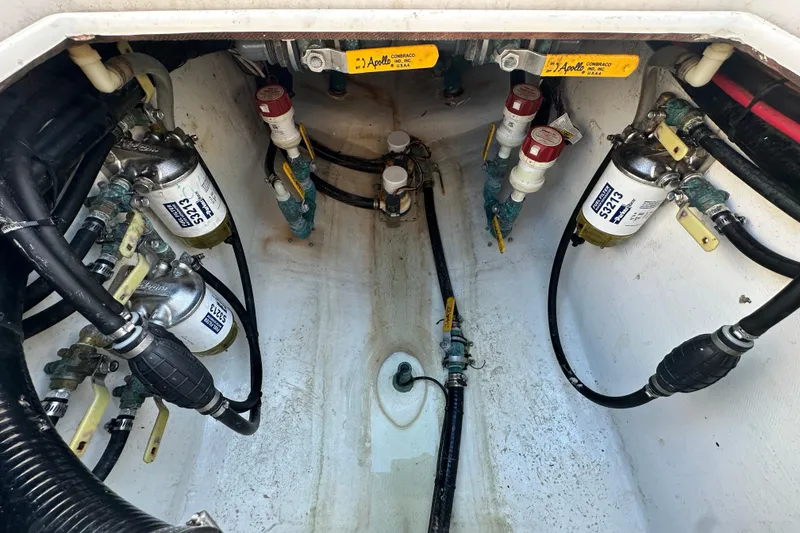 Slide: The Image of Engine compartment of a 2005 Contender 36 Cuddy boat, showing fuel filters and hoses. - 22