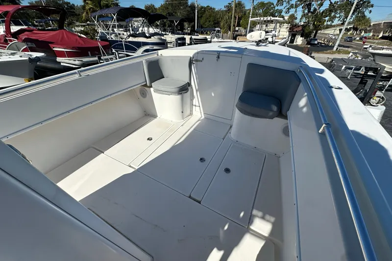 Slide: The Image of 2005 Contender 36 Cuddy boat interior with seating and storage, docked among other boats. - 28