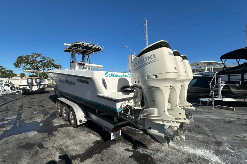 Slide: The Image of 2005 Contender 36 Cuddy boat with triple Suzuki outboard engines on a trailer. - 4