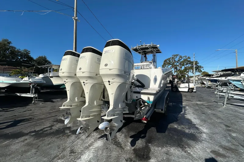 Slide: The Image of 2005 Contender 36 Cuddy boat with triple outboard engines in a marina setting. - 6