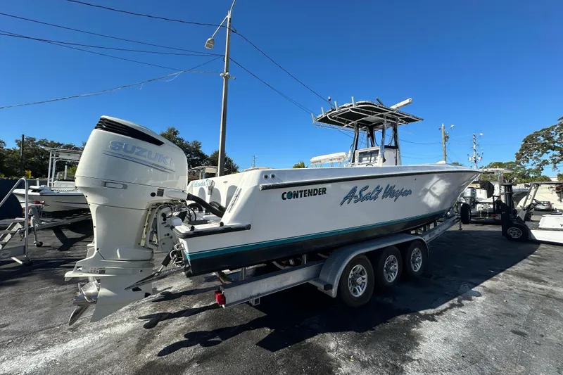 Slide: The Image of 2005 Contender 36 Cuddy boat on trailer with Suzuki outboard motor, parked outdoors. - 7