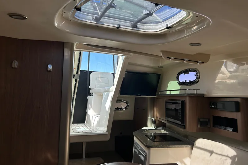 Slide: The Image of Interior of 2015 Boston Whaler 285 Conquest boat with modern kitchen and seating area. - 11
