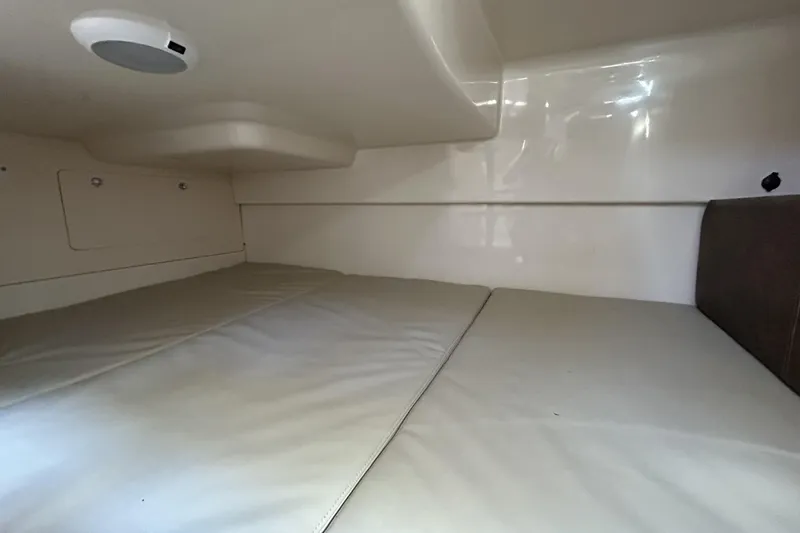 Slide: The Image of 2015 Boston Whaler 285 Conquest cabin interior with cushioned sleeping area. - 12