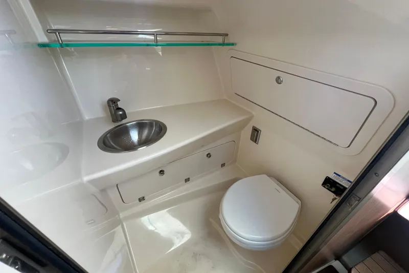Slide: The Image of 2015 Boston Whaler 285 Conquest boat bathroom with sink and toilet. - 14