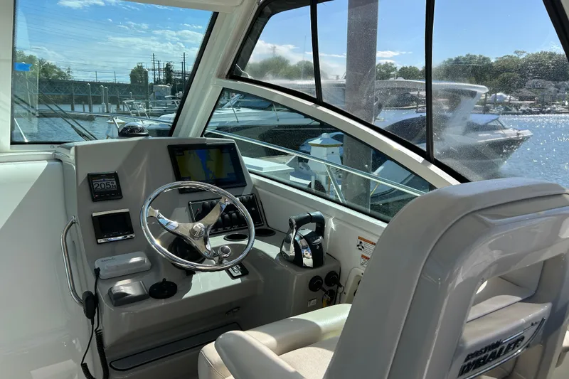 Slide: The Image of 2015 Boston Whaler 285 Conquest helm with steering wheel and navigation system. - 6