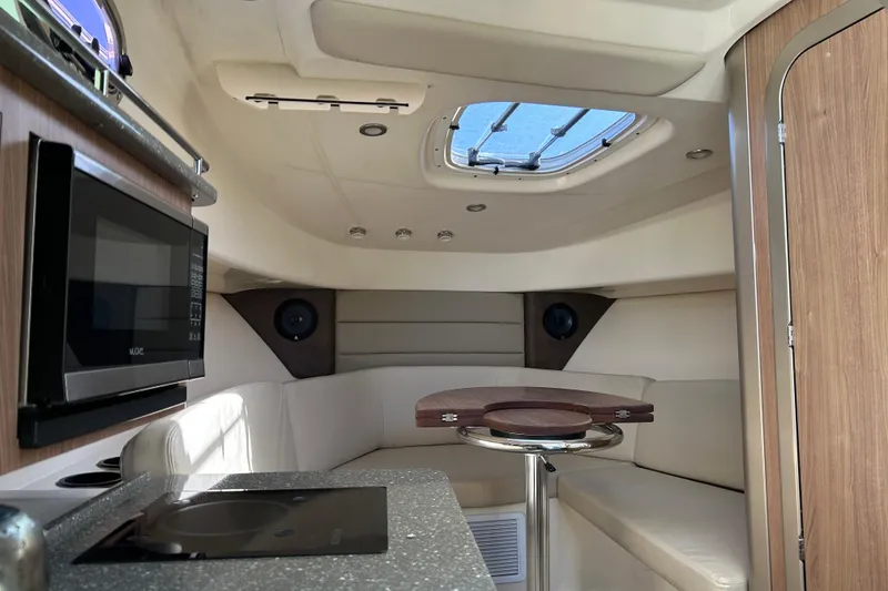 Slide: The Image of Interior of 2015 Boston Whaler 285 Conquest with seating, table, and kitchenette. - 9