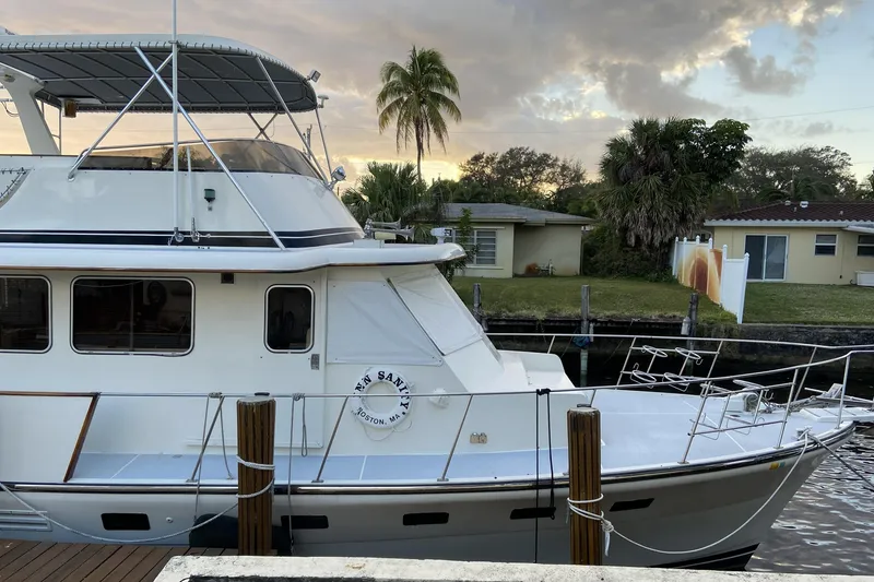 Slide: The Image of 1988 Cheoy Lee 51 Long Range Cockpit Motor Yacht docked near waterfront homes. - 2