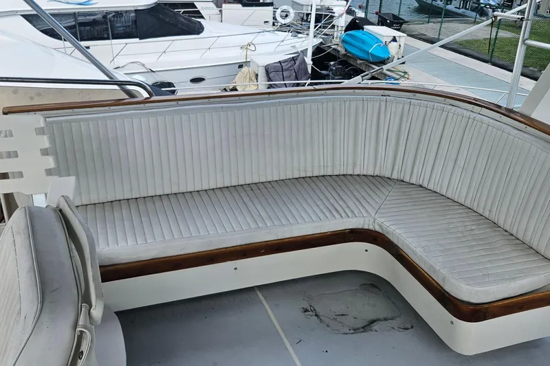 Slide: The Image of 1988 Cheoy Lee 51 Yacht cockpit with white cushioned seating and wooden trim. - 25