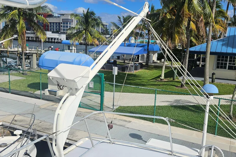 Slide: The Image of 1988 Cheoy Lee 51 Long Range Cockpit Motor Yacht docked near palm trees and marina. - 28