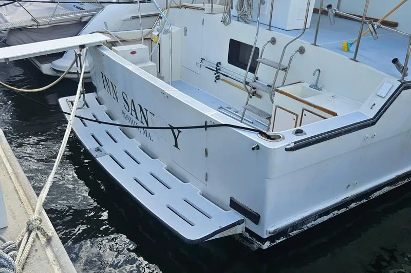 Slide: The Image of 1988 Cheoy Lee 51 Long Range Cockpit Motor Yacht docked, featuring spacious deck and ladder. - 3