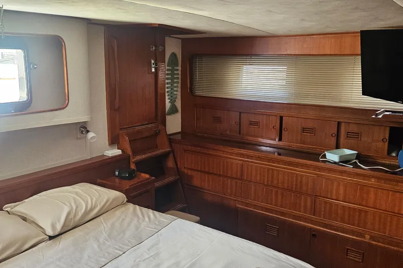 Slide: The Image of Interior of 1988 Cheoy Lee 51 Yacht, featuring wood cabinetry and a cozy sleeping area. - 31
