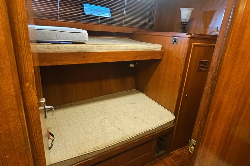 Slide: The Image of 1988 Cheoy Lee 51 Yacht interior with wooden bunk beds and cozy lighting. - 39