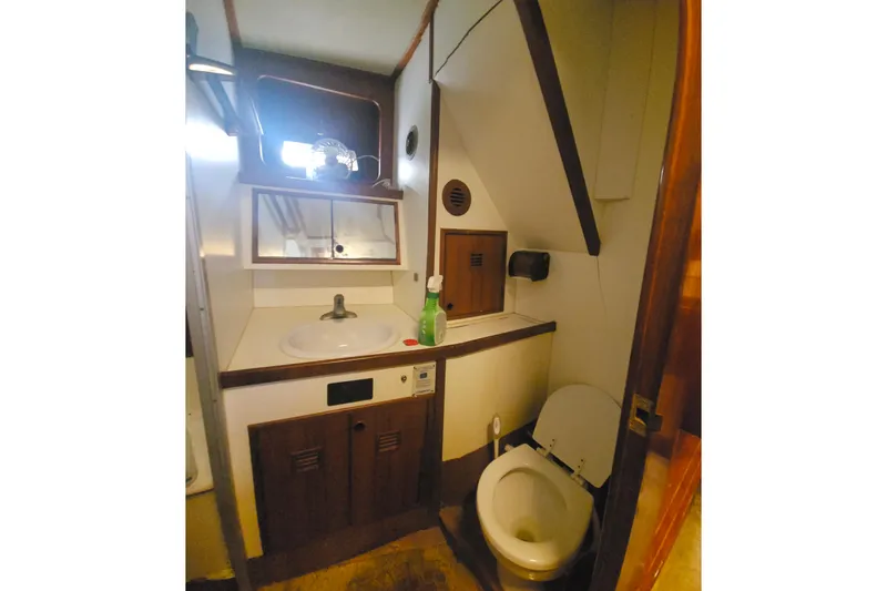 Slide: The Image of 1988 Cheoy Lee 51 Yacht bathroom with sink, mirror, and toilet in compact space. - 43