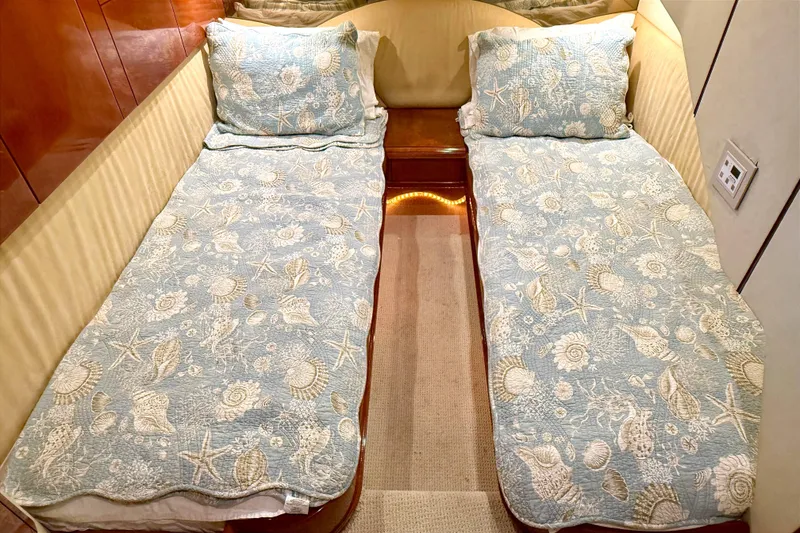 Slide: The Image of Twin beds with seashell-patterned bedding in a 2000 Fairline Squadron 55 yacht cabin. - 20