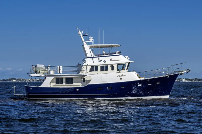 Slide: The Image of 2017 Kadey-Krogen 58EB yacht cruising on open water under clear blue skies. - 1