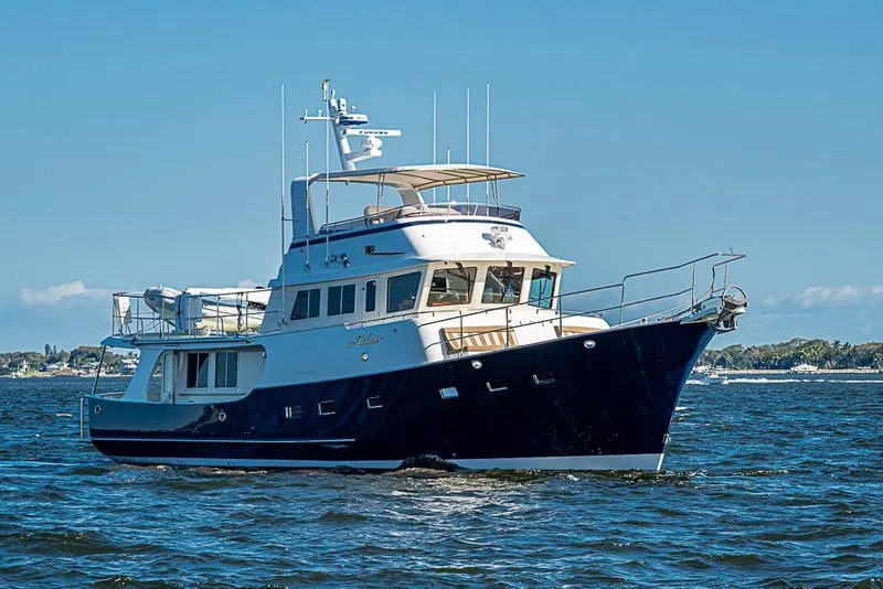 Slide: The Image of 2017 Kadey-Krogen 58EB yacht cruising on open water under clear blue skies. - 2