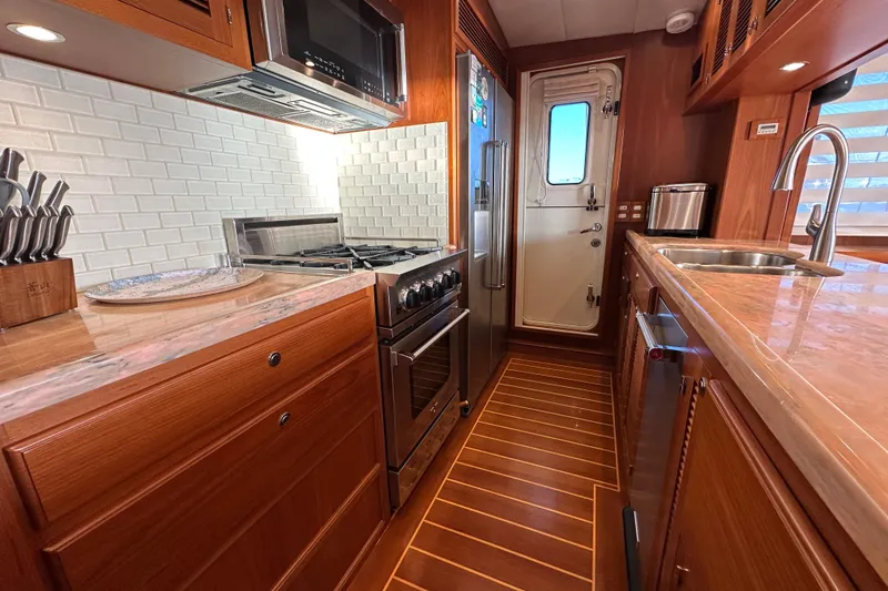 Slide: The Image of Luxurious 2017 Kadey-Krogen 58EB yacht kitchen with modern appliances and elegant wood finishes. - 20