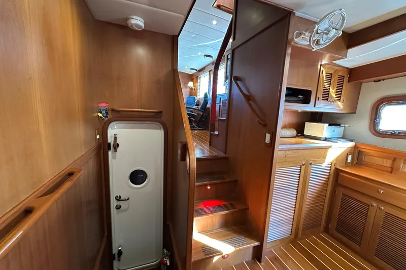 Slide: The Image of Interior of 2017 Kadey-Krogen 58EB yacht, featuring wooden cabinetry and stairs. - 29