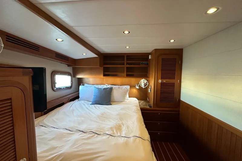 Slide: The Image of Luxurious 2017 Kadey-Krogen 58EB yacht bedroom with cozy bedding and elegant wood finishes. - 45