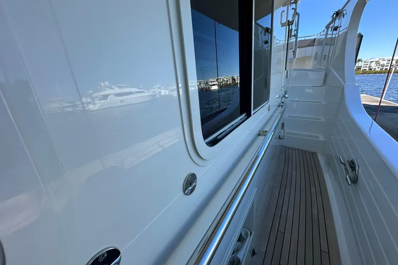 Slide: The Image of Side deck of 2017 Kadey-Krogen 58EB yacht with polished railings and wooden flooring. - 57