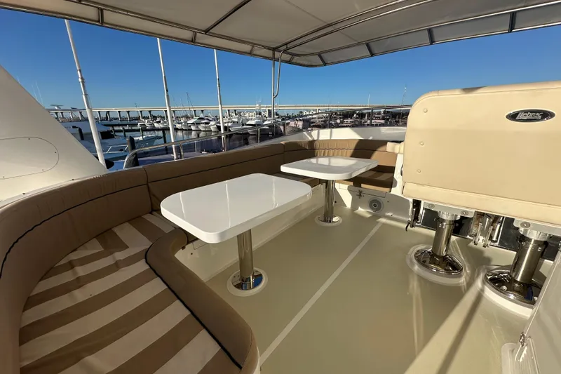 Slide: The Image of 2017 Kadey-Krogen 58EB yacht deck with seating and tables, overlooking marina. - 66