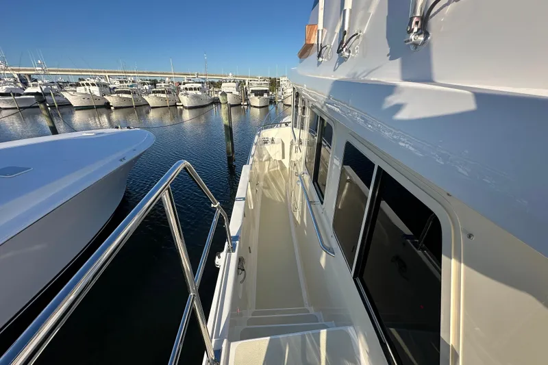 Slide: The Image of 2017 Kadey-Krogen 58EB yacht docked at marina, side view with railing and windows. - 80