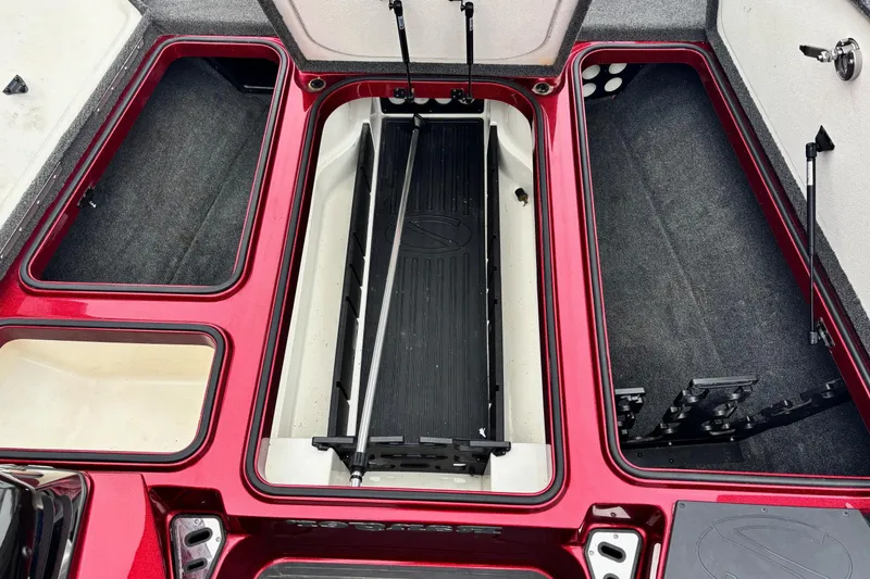 Slide: The Image of 2018 Ranger Z518 Comanche boat storage compartments, open and organized, with red and gray interior. - 6