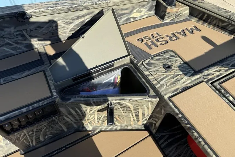 Slide: The Image of 2026 Tracker Grizzly 1756 T Marsh boat interior with camo design and storage compartment. - 13