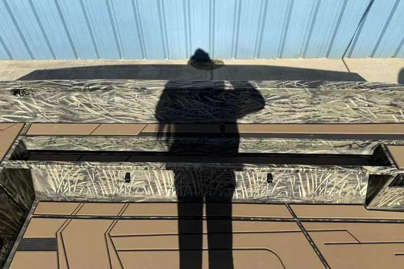 Slide: The Image of 2026 Tracker Grizzly 1756 T Marsh boat with camouflage design and shadow on deck. - 9