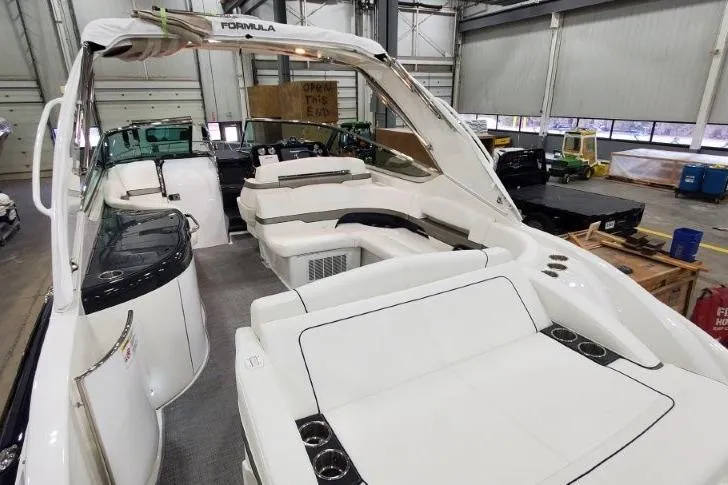 Slide: The Image of 2016 Formula 370 Super Sport boat interior with white seating in a warehouse setting. - 21