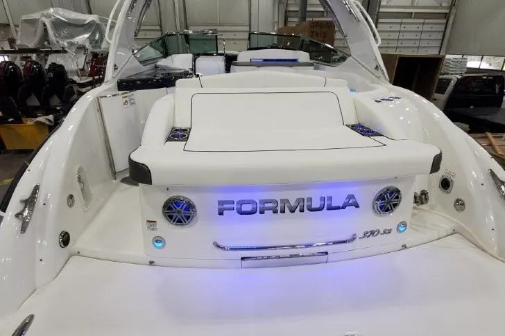 Slide: The Image of 2016 Formula 370 Super Sport boat with illuminated branding and sleek design in a showroom. - 6